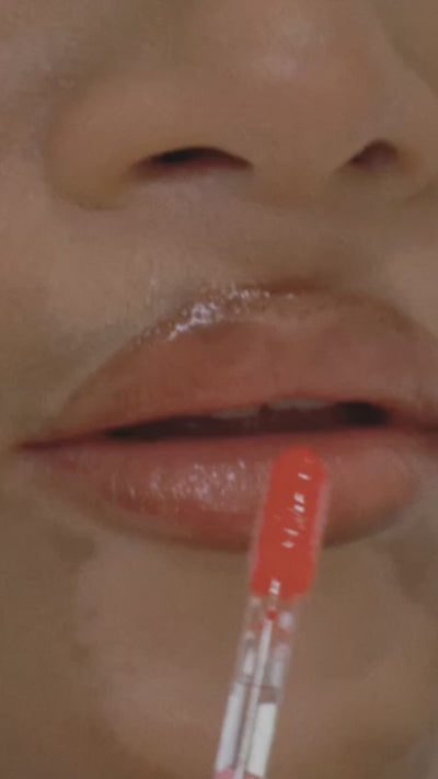 Model applying the TRU SKN lip gloss collection, demonstrating the rich pigment and smooth glide of the formula while interacting with the camera in a fun, lively way.